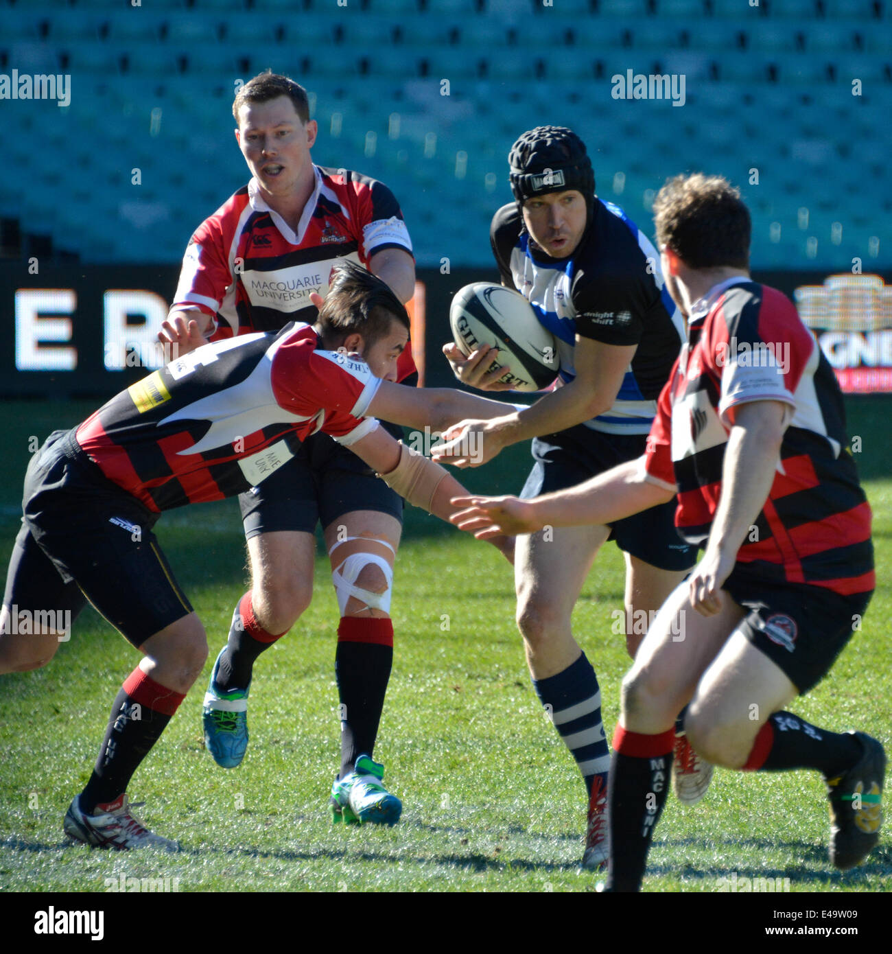 Sydney, Australia. 6th July, 2014. Macquarie University players attempt a tackle on Sydney Convicts forward during historic match against Macquarie University at the Allianz Stadium. Credit:  MediaServicesAP/Alamy Live News Stock Photo