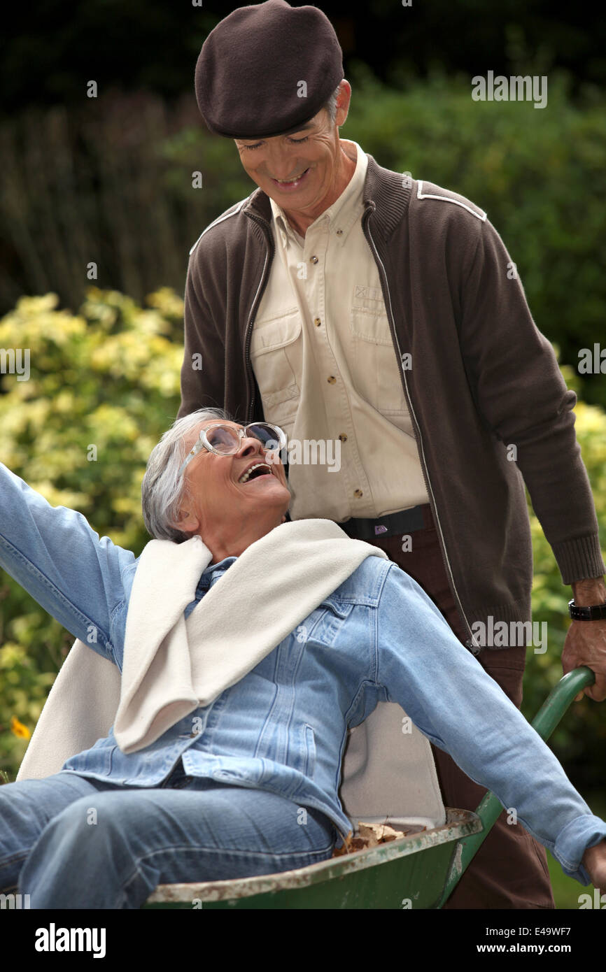 Elderly couple in wheelbarrow Stock Photo Alamy