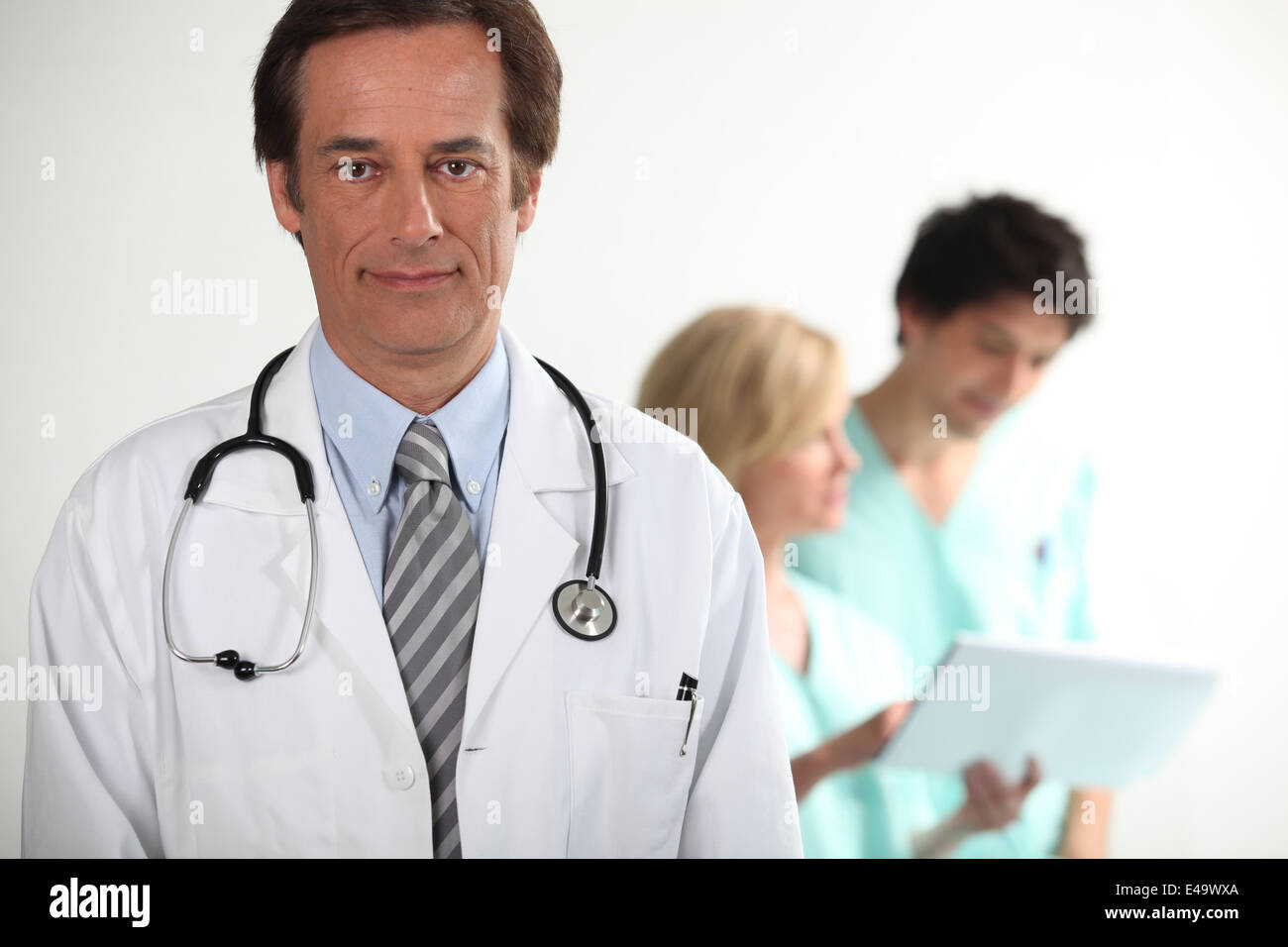 Doctor stood in front of colleagues Stock Photo