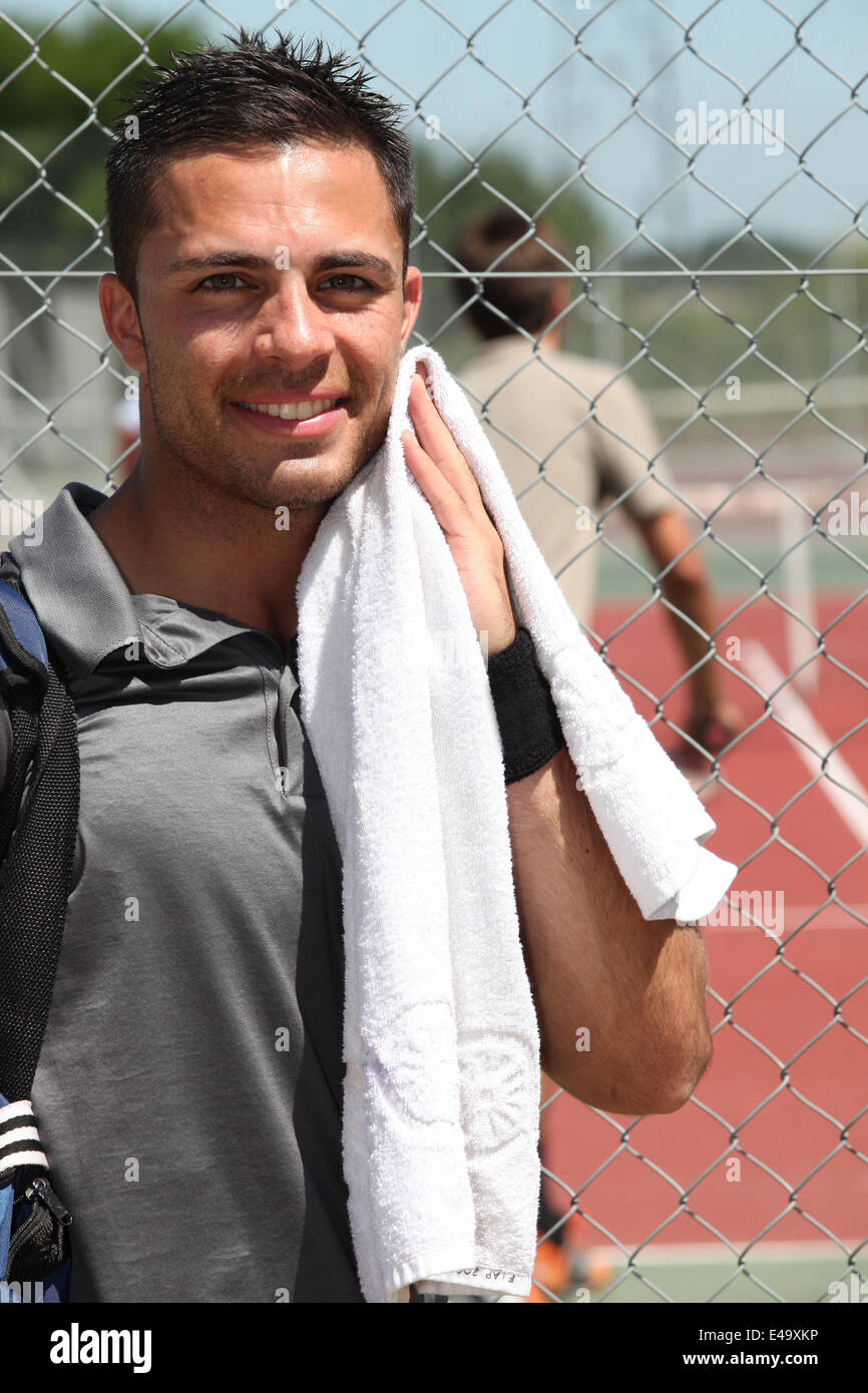 Male tennis player towelling off after game Stock Photo