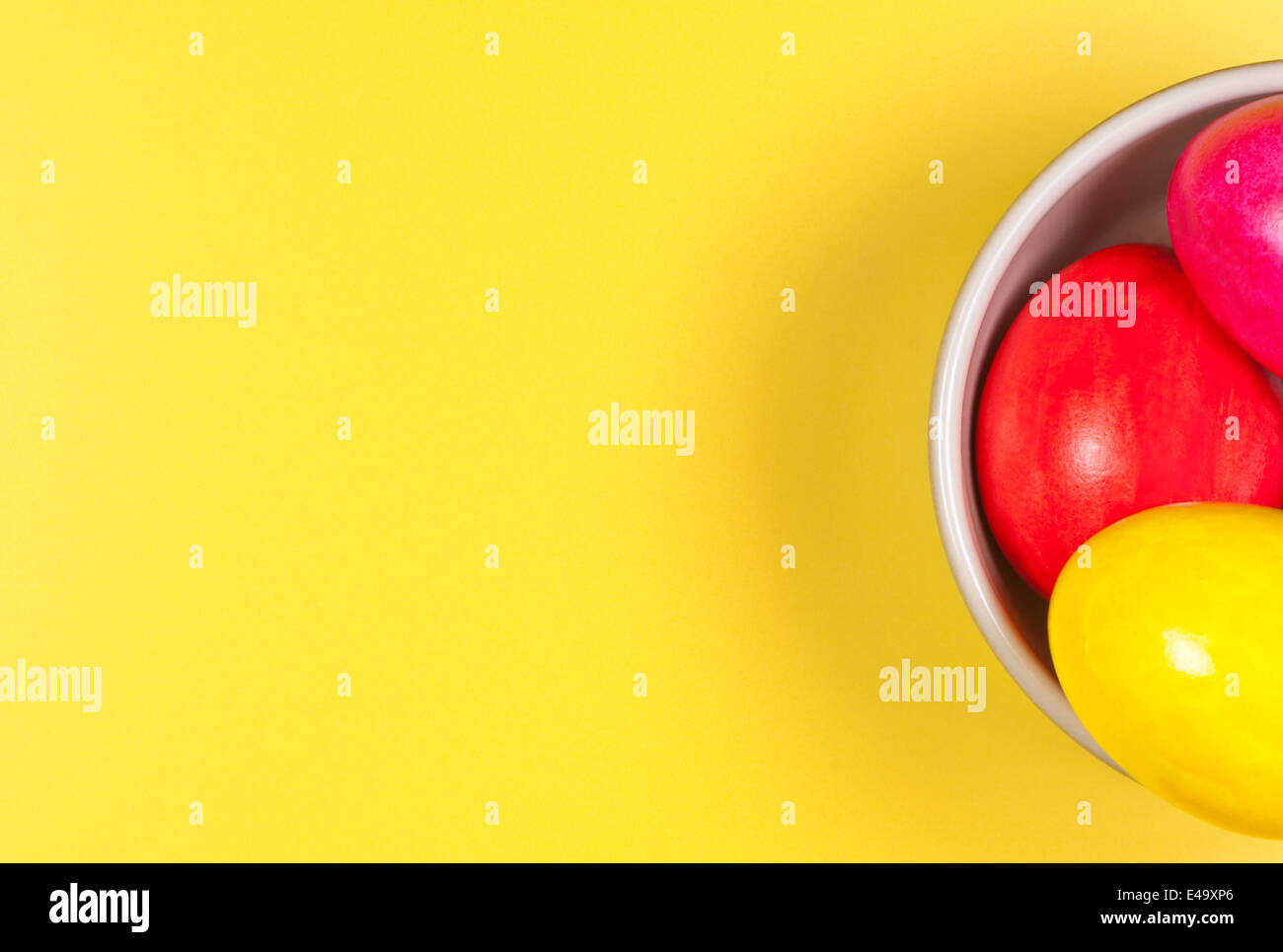 Easter eggs in bowl on yellow background. Stock Photo