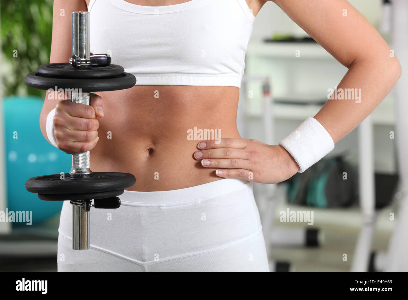 Woman in the gym lifting weights Stock Photo