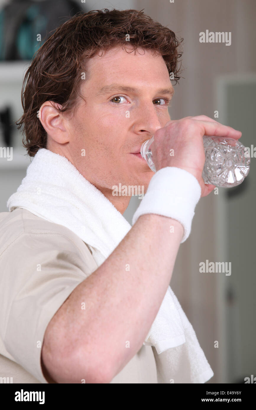 Man drinking from water bottle in gym Stock Photo - Alamy