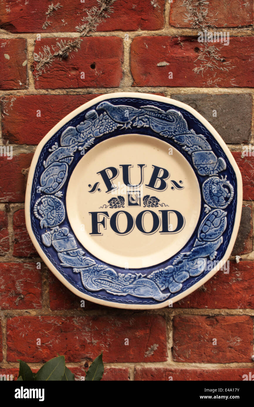 Decorated plate promoting Pub Food on the outside wall of an English pub Stock Photo