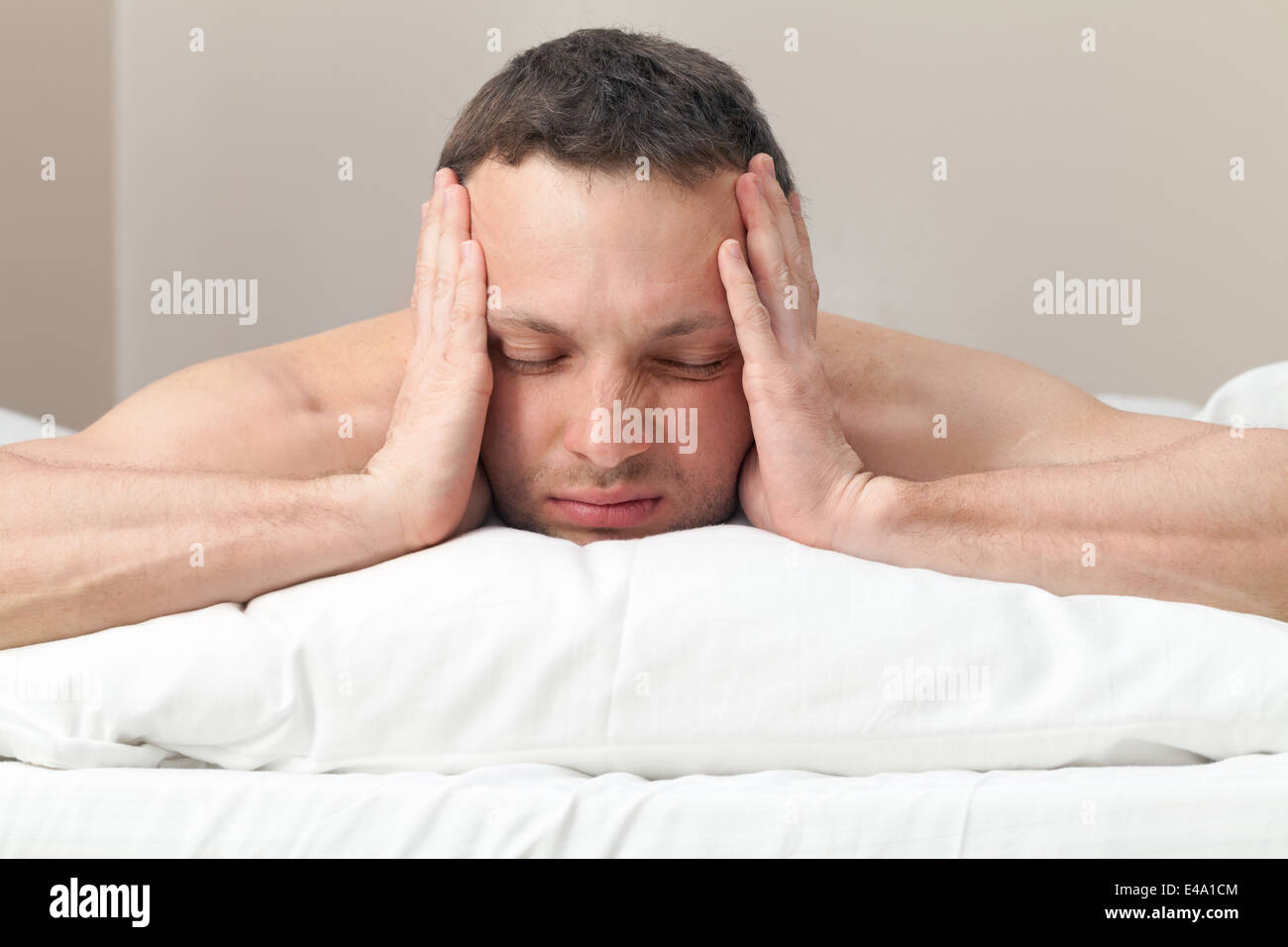 Portrait of Young man in bed with headache Stock Photo