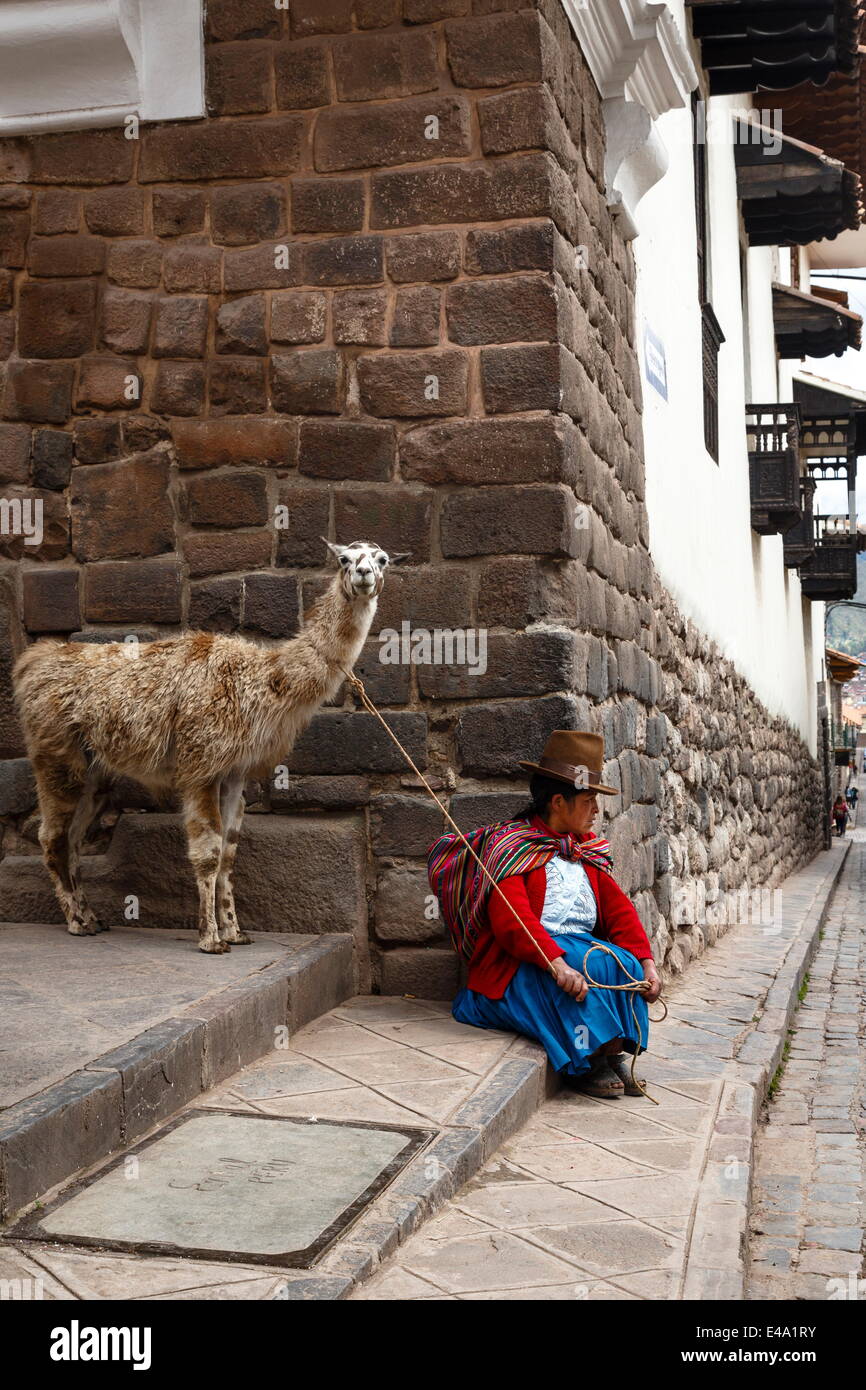 Quechua woman with llama along an Inca wall in San Blas neighborhood, Cuzco, Peru, South America Stock Photo