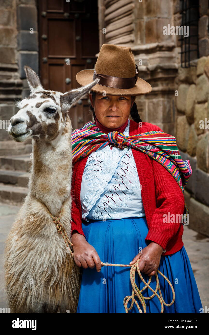 Portrait of a Quechua woman with llama along an Inca wall in San Blas neighborhood, Cuzco, Peru, South America Stock Photo