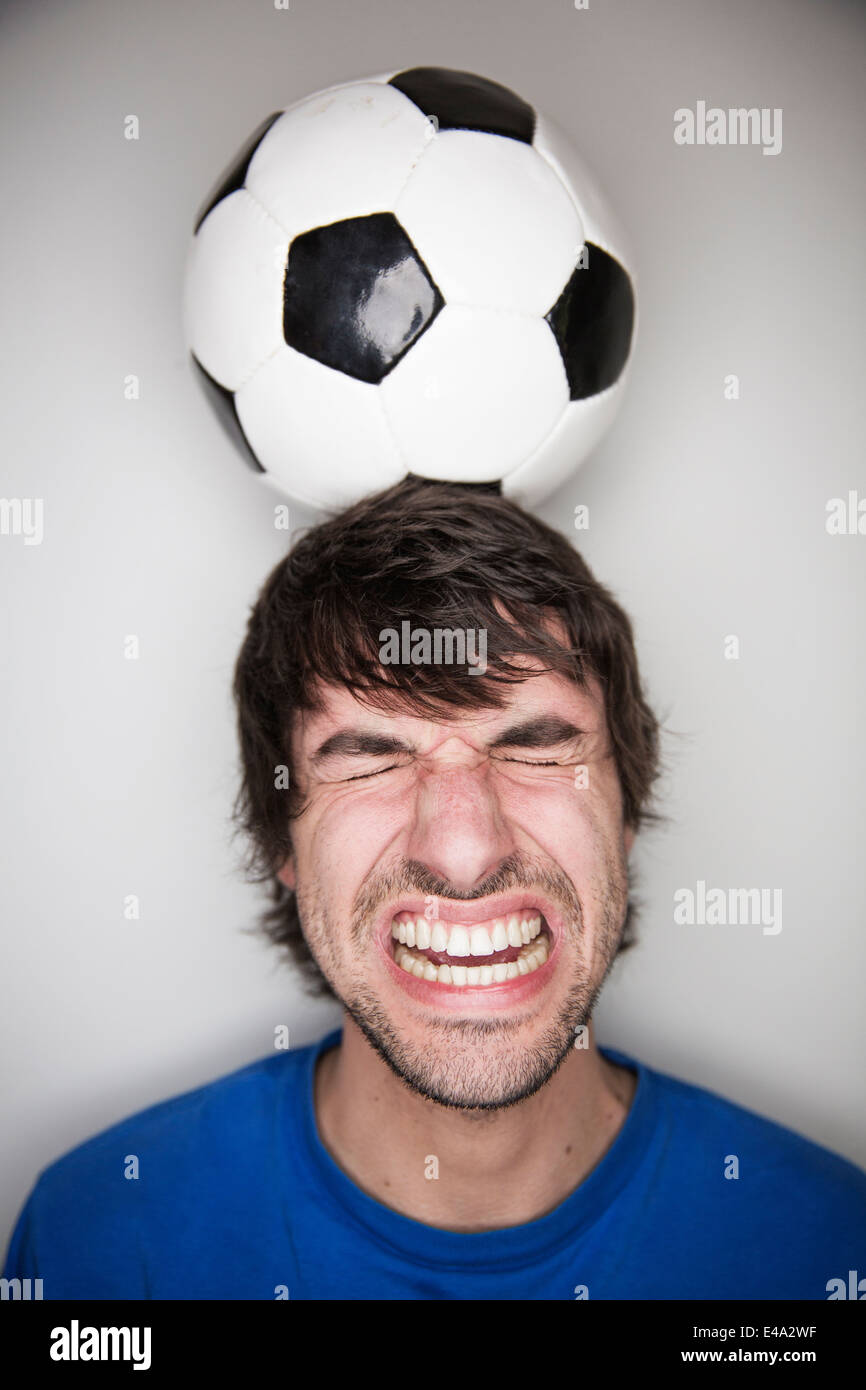 Young man balancing soccer ball on head Stock Photo Alamy
