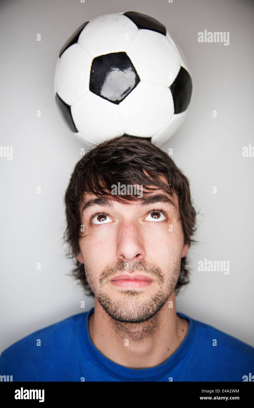 Young man balancing soccer ball on head Stock Photo Alamy