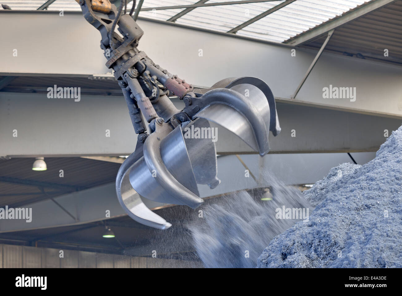 Clamshell grabbing aluminium chips in a scrap metal recycling plant
