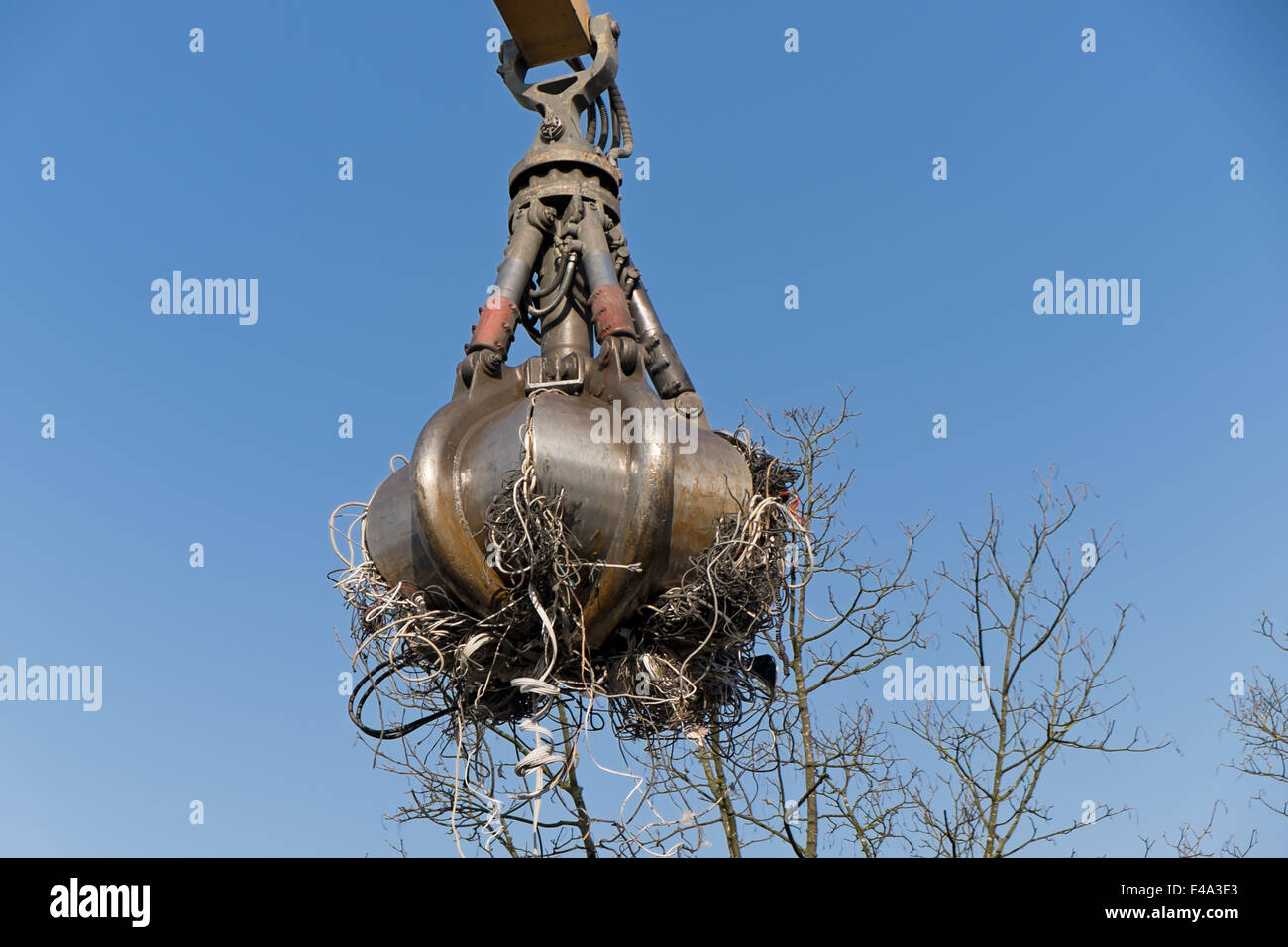 Clamshell grabbing electrical waste at a scrap metal recycling plant