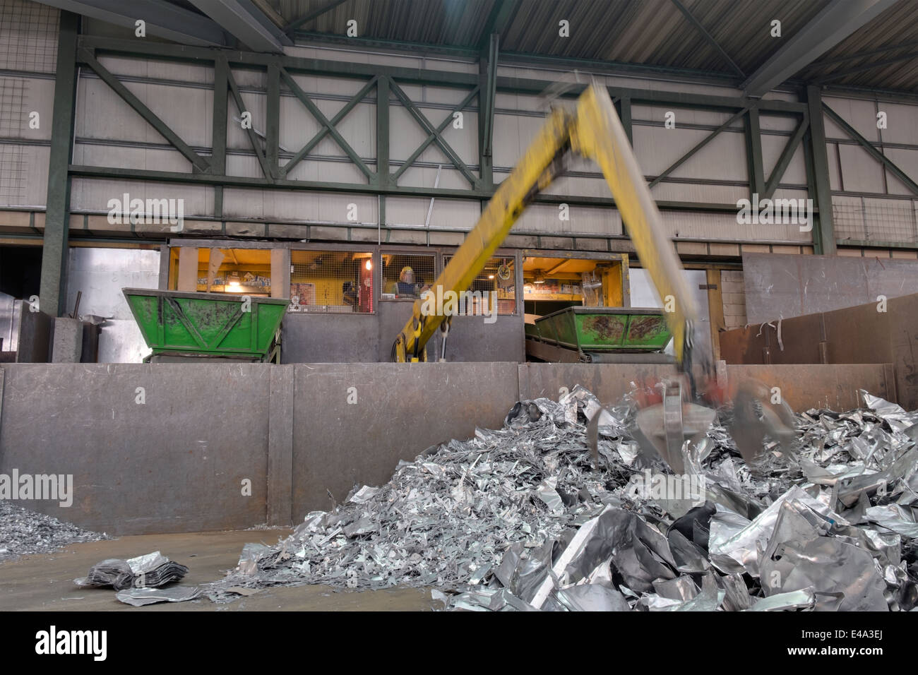 Clamshell grabbing aluminium chunks in a scrap metal recycling plant
