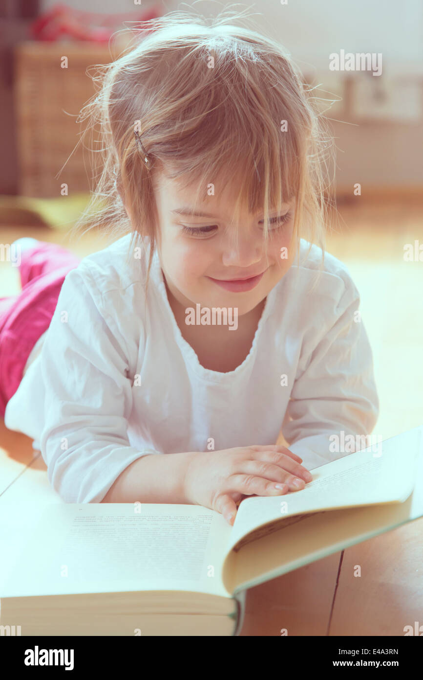 Portrait of smiling little girl with book Stock Photo - Alamy