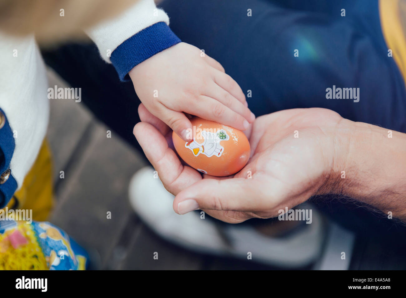 Toddler giving his grandfather an Easter egg, close-up Stock Photo