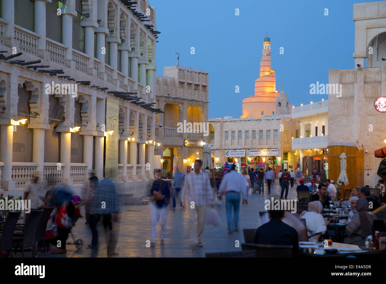 Souq Waqif looking towards the illuminated spiral mosque of the Kassem Darwish Fakhroo Islamic Centre, Doha, Qatar, Middle East Stock Photo