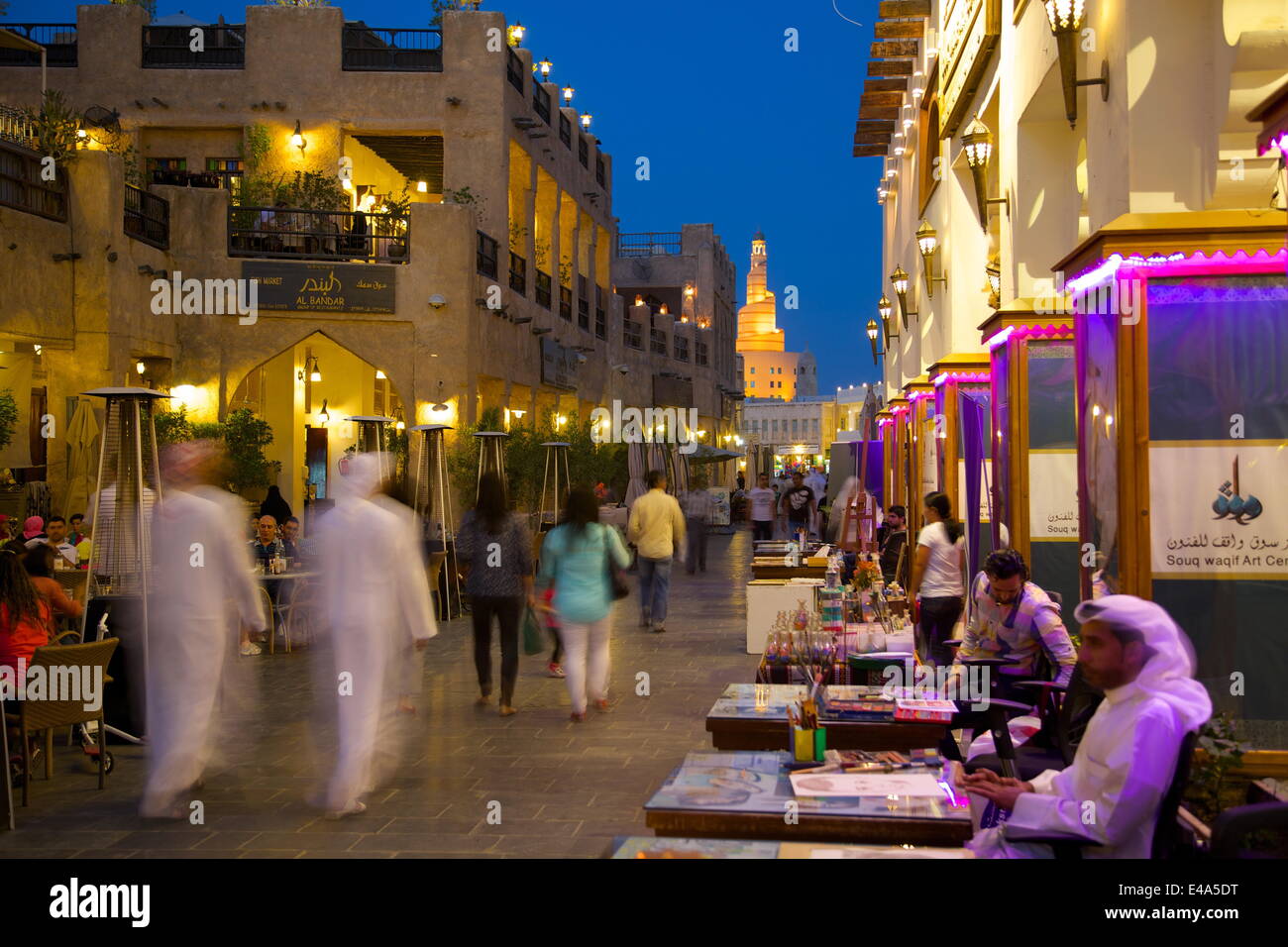 Souq Waqif looking towards the illuminated spiral mosque of the Kassem Darwish Fakhroo Islamic Centre, Doha, Qatar, Middle East Stock Photo