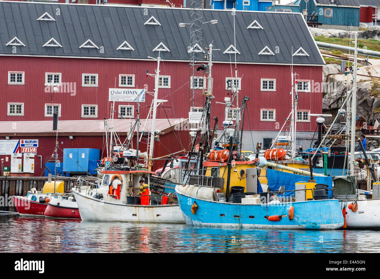 Commercial fishing and whaling boats line the busy inner harbour in the town of Ilulissat, Greenland, Polar Regions Stock Photo