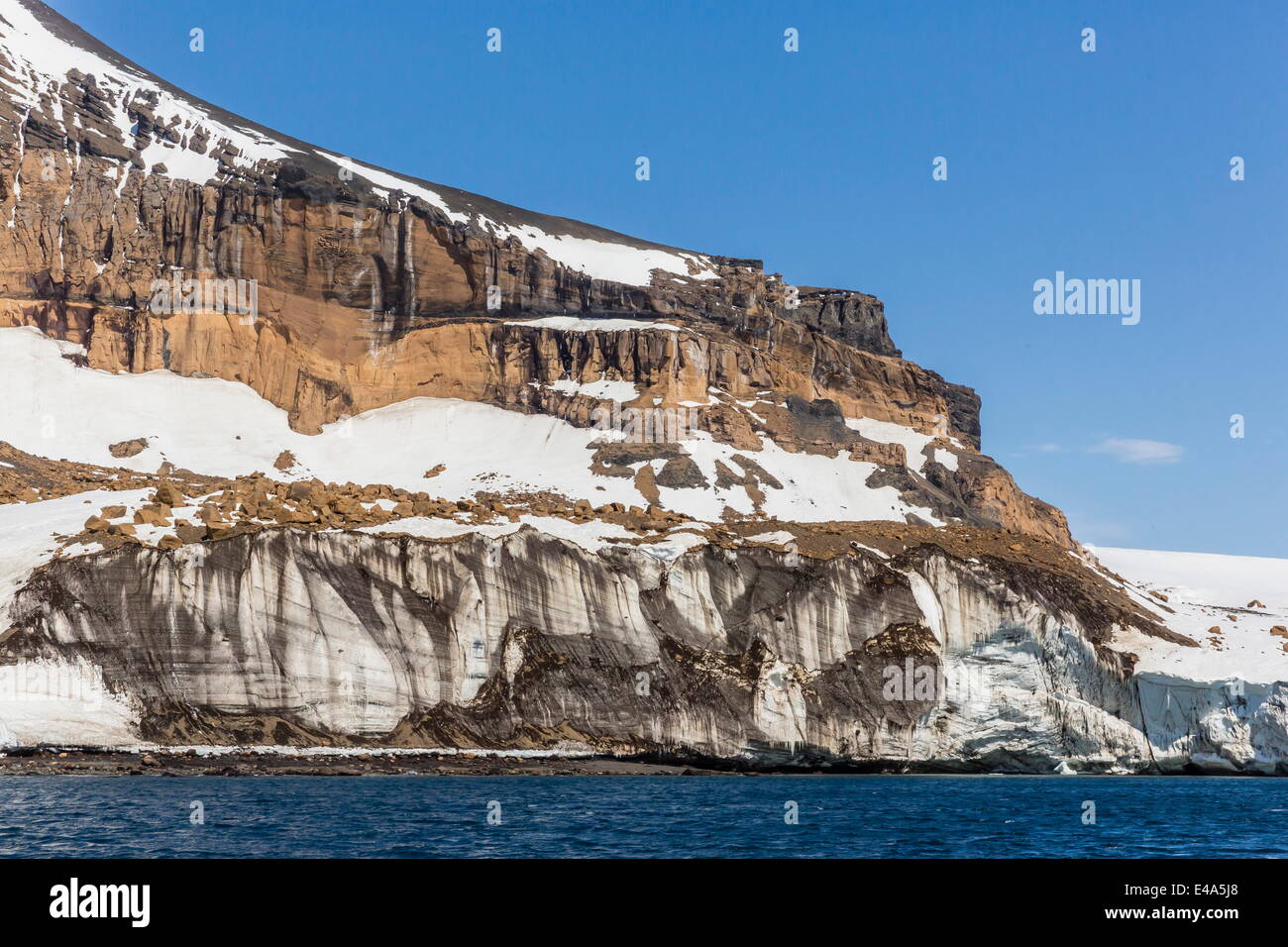 Rust-colored volcanic tuff cliffs above a glacier at Brown Bluff, eastern side of the Tabarin Peninsula, Weddell Sea, Antarctica Stock Photo