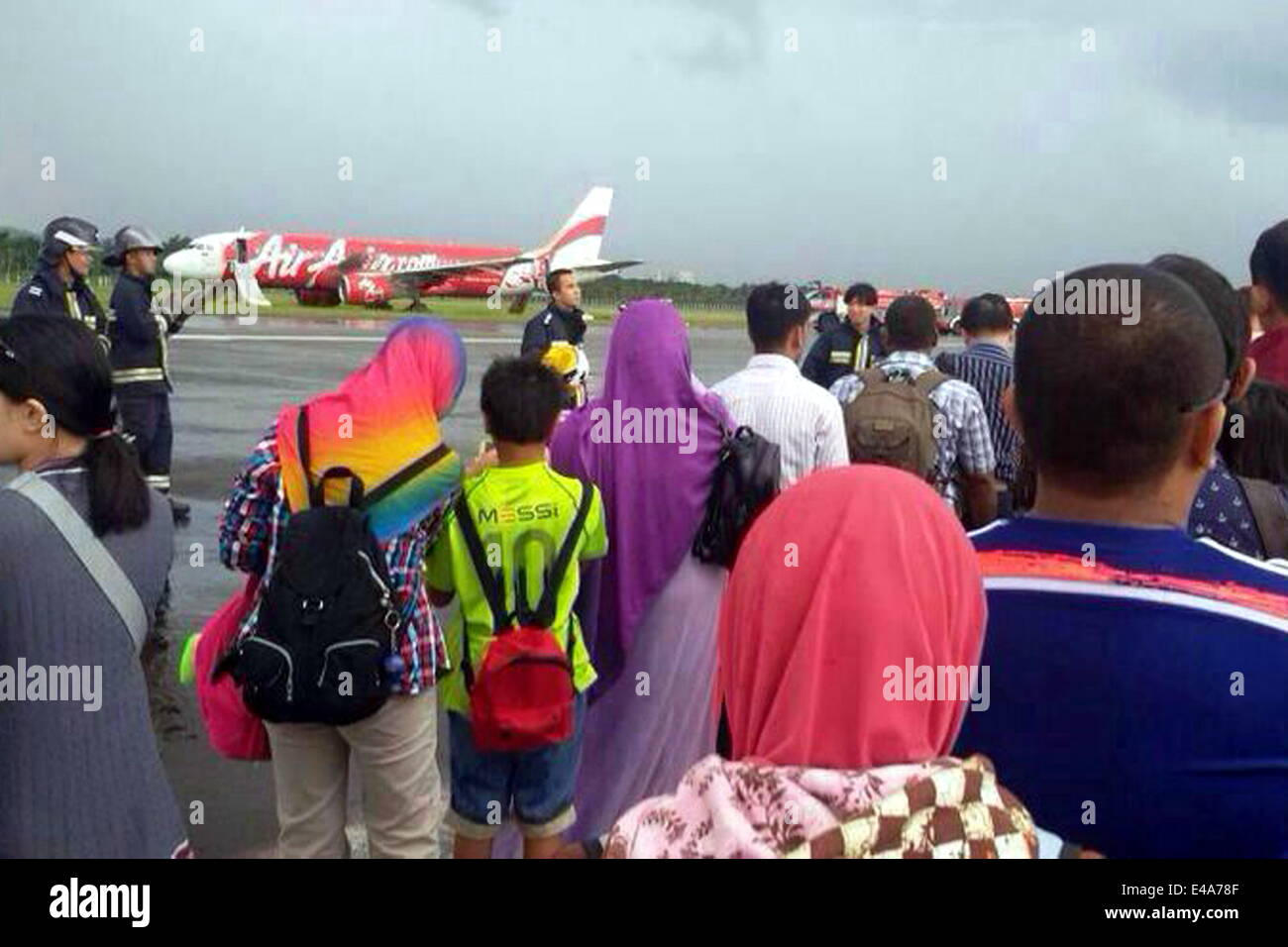 Bandar Seri Begawan, Brunei. 7th July, 2014. Passengers carry their luggages at the Brunei International Airport in Bandar Seri Begawan, Brunei, July 7, 2014. An AirAsia flight AK278 with 102 passengers and seven crew members on board from Kuala Lumpur to Brunei skidded the runway at the Brunei International Airport Monday afternoon while it was trying to land during a heavy rain in the counry. Nobody was injured in the accident. Credit:  Jeffrey Wong/Xinhua/Alamy Live News Stock Photo