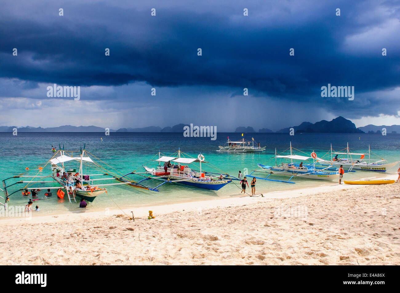 Outrigger boats before a strom anchoring on a sandy beach  in  the Bacuit archipelago, Palawan, Philippines, Southeast Asia Stock Photo