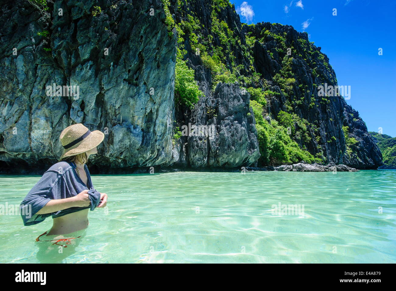 Woman standing in clear water in the Bacuit archipelago, Palawan, Philippines, Southeast Asia Stock Photo