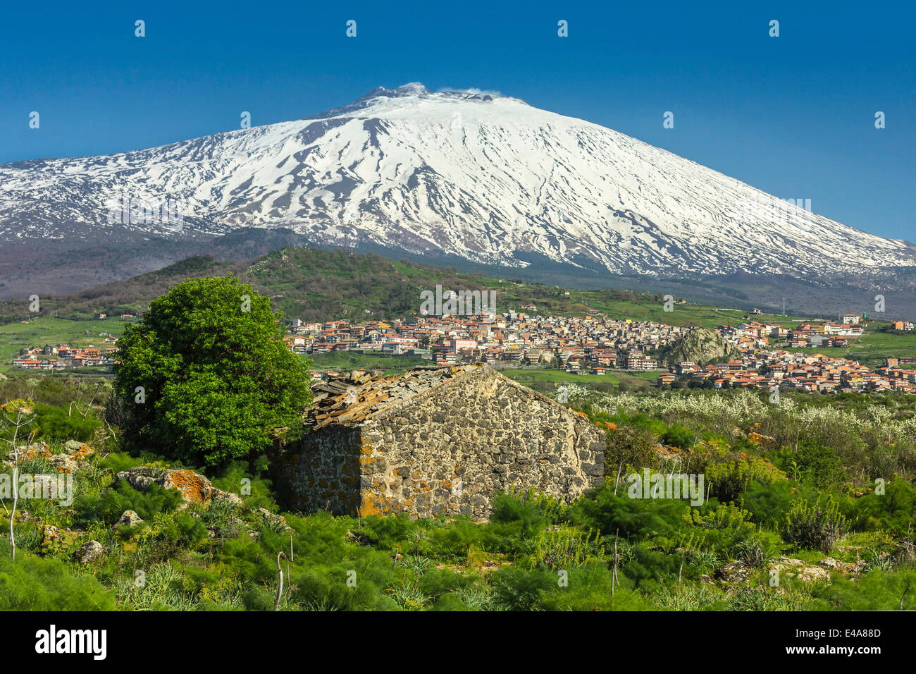 Snow-capped volcano Mount Etna, UNESCO, looms over the Maletto, Catania Province, Sicily, Italy Stock Photo
