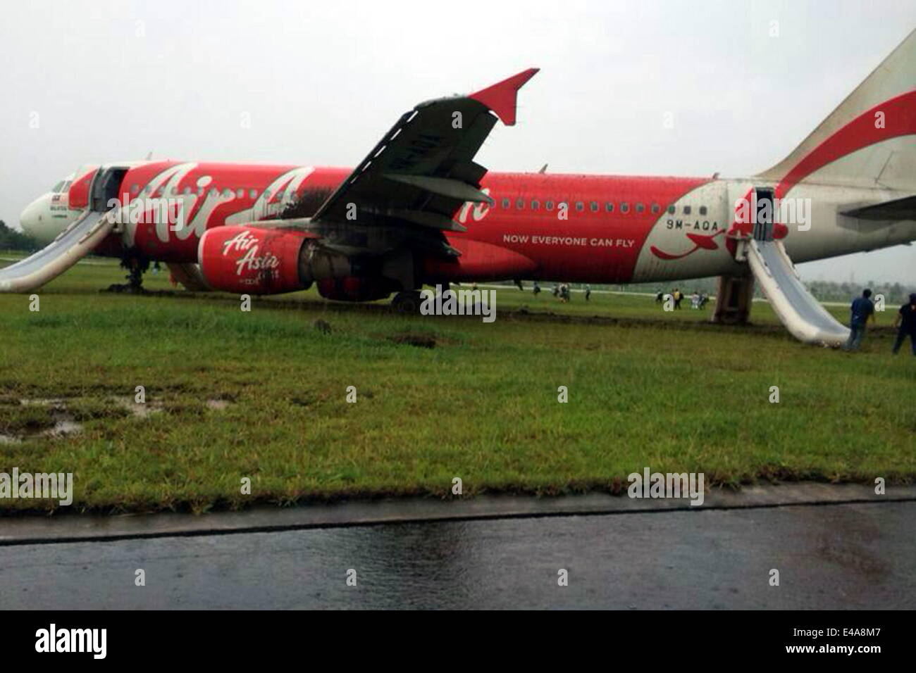 Bandar Seri Begawan, Brunei. 7th July, 2014. The skidded plane is seen at the Brunei International Airport in Bandar Seri Begawan, Brunei, July 7, 2014. An AirAsia flight AK278 with 102 passengers and seven crew members on board from Kuala Lumpur to Brunei skidded the runway at the Brunei International Airport Monday afternoon while it was trying to land during a heavy rain in the counry. Nobody was injured in the accident. Credit:  Jeffrey Wong/Xinhua/Alamy Live News Stock Photo