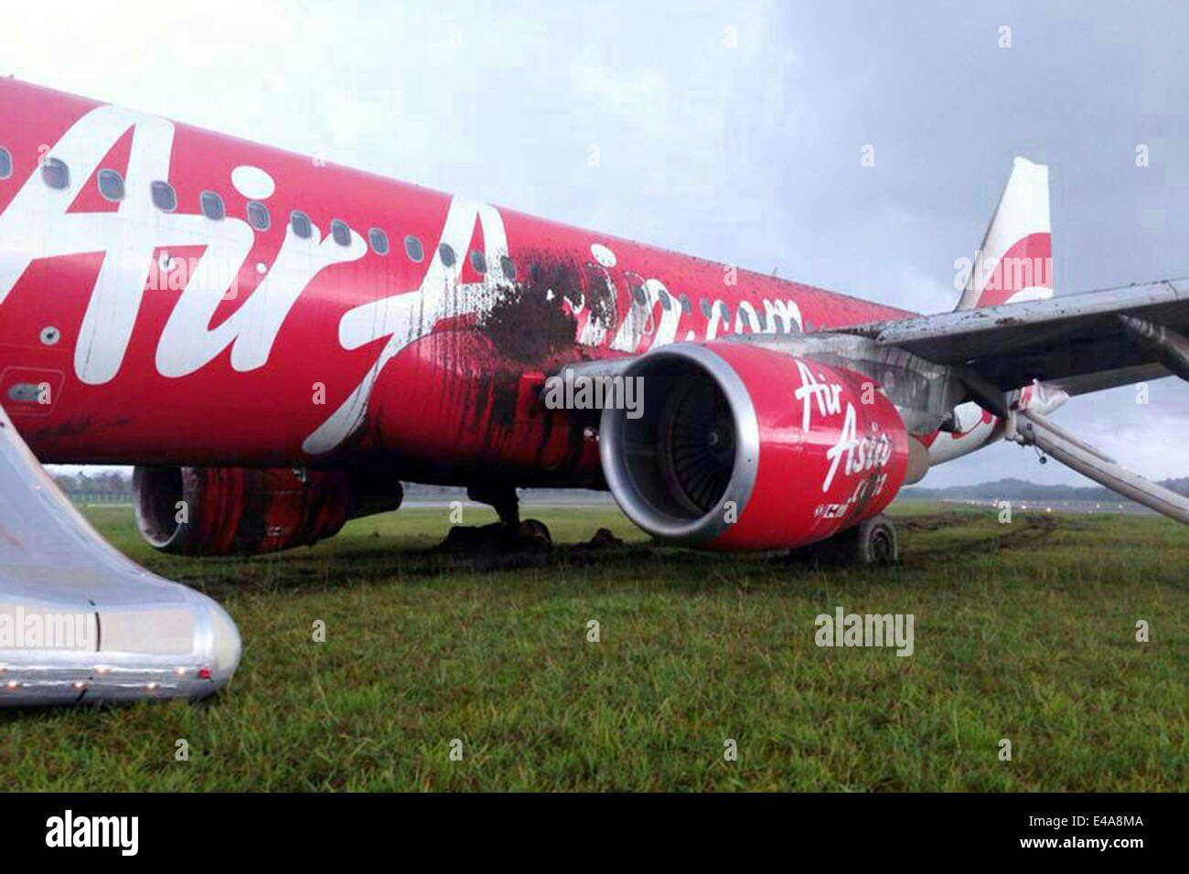 Bandar Seri Begawan, Brunei. 7th July, 2014. The skidded plane is seen at the Brunei International Airport in Bandar Seri Begawan, Brunei, July 7, 2014. An AirAsia flight AK278 with 102 passengers and seven crew members on board from Kuala Lumpur to Brunei skidded the runway at the Brunei International Airport Monday afternoon while it was trying to land during a heavy rain in the counry. Nobody was injured in the accident. Credit:  Jeffrey Wong/Xinhua/Alamy Live News Stock Photo
