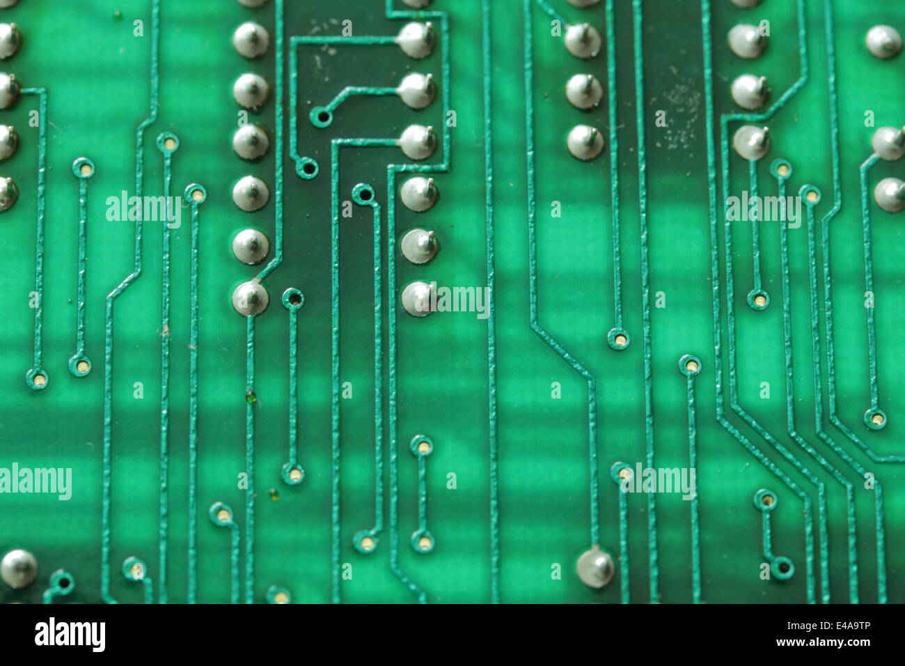 Green printed circuit board with solder points, closeup Stock Photo