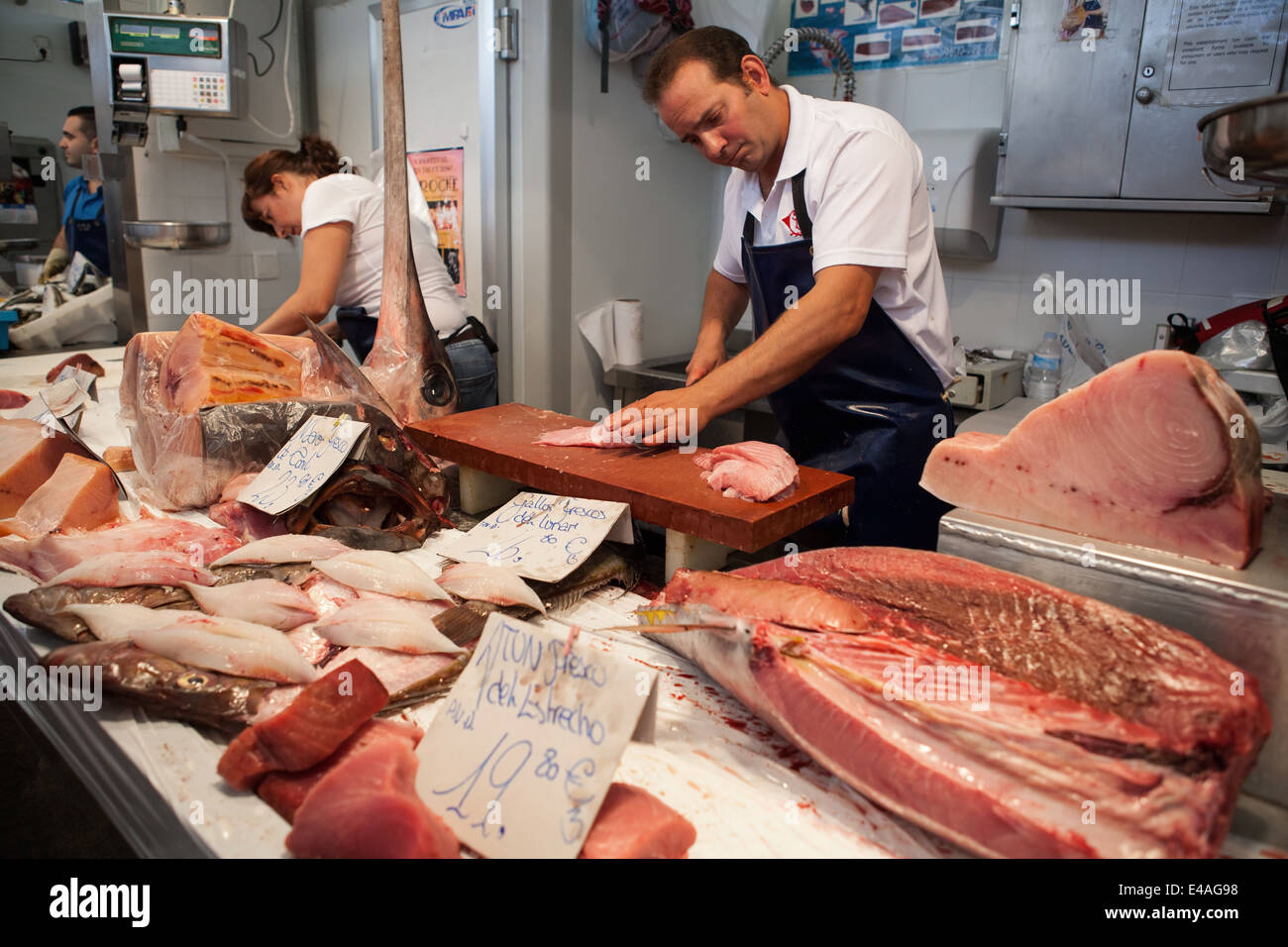 A fishmonger fillets fish in Cadiz market Stock Photo - Alamy
