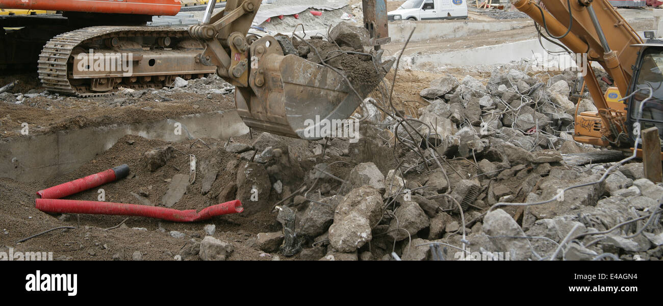 Breaking up concrete road surface with a pneumatic hammer and excavator. Barcelona, Spain. Stock Photo