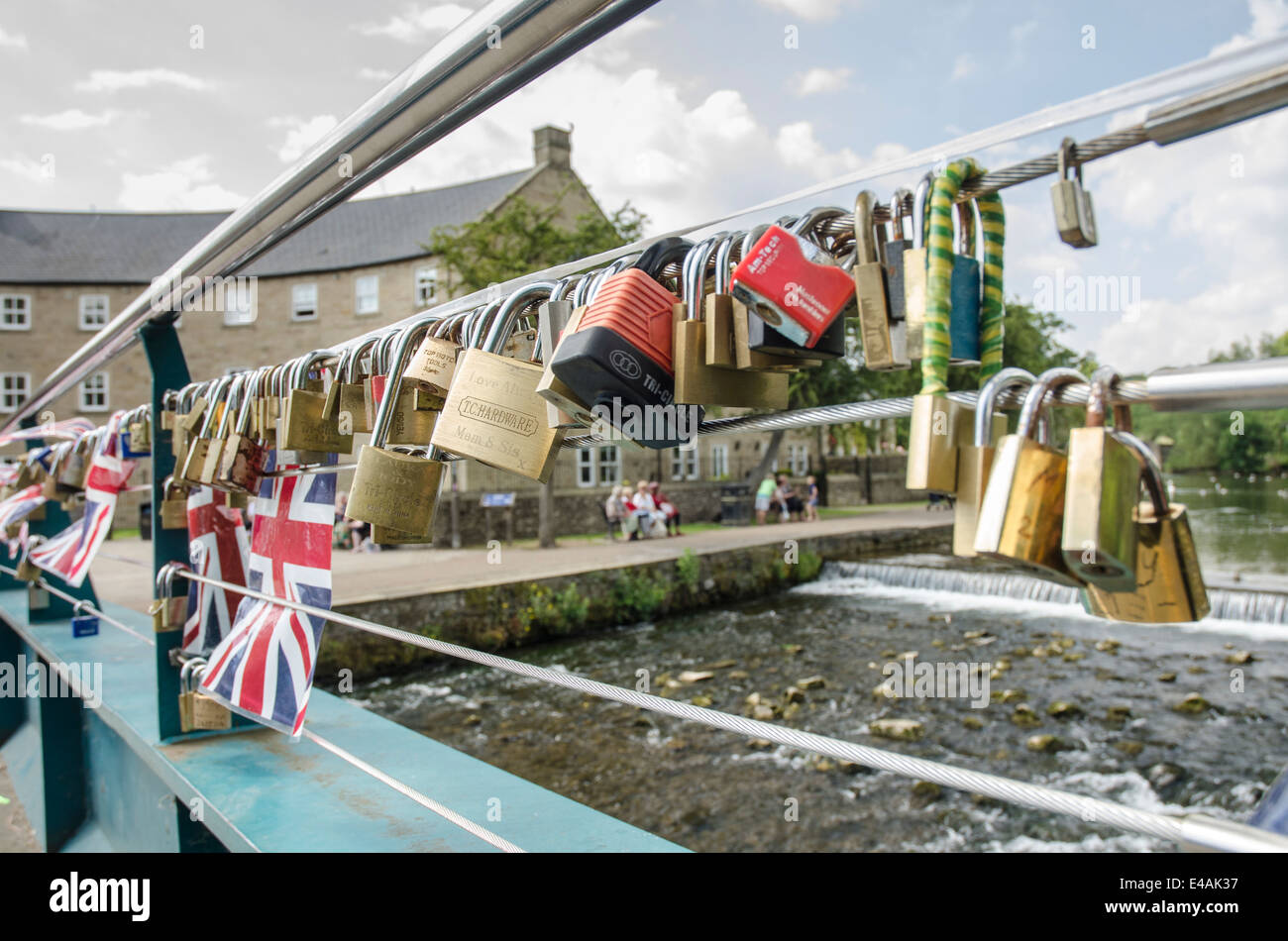 Inscribed padlocks attached as love tokens to a foot bridge in Bakewell Derbyshire Stock Photo