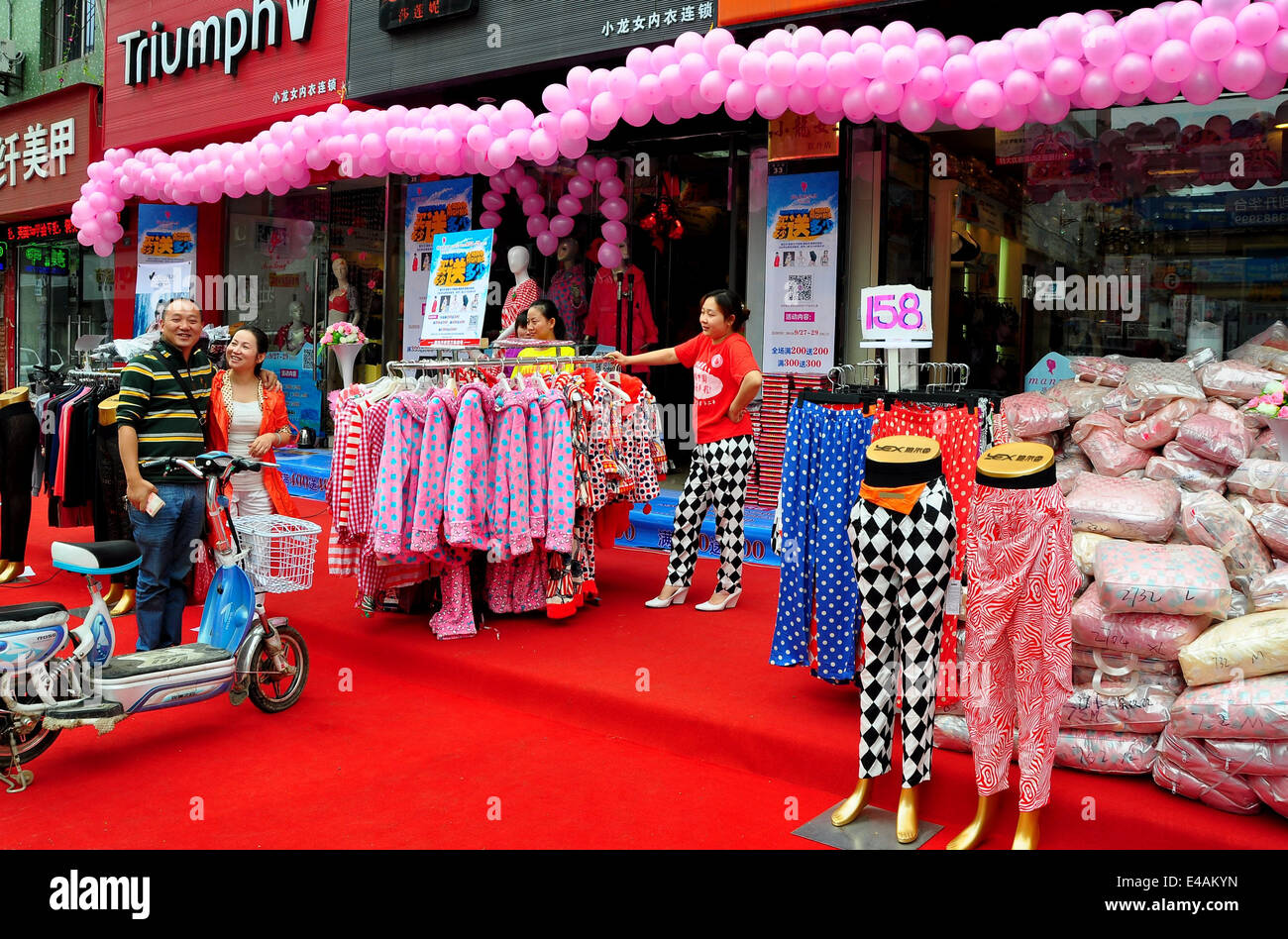 PENGZHOU, CHINA: Garlands of pink balloons decorate a newly opened clothing shop Stock Photo