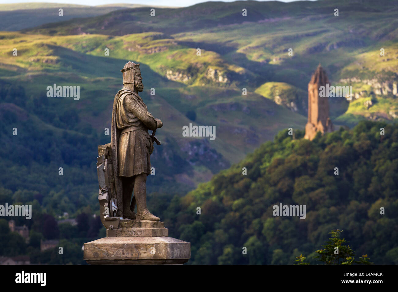 Carved stone statue of Robert the Bruce, King of Scotland on the castle esplanade, and Wallace Monument, Stirling, Stirlingshire, Scotland, UK Stock Photo