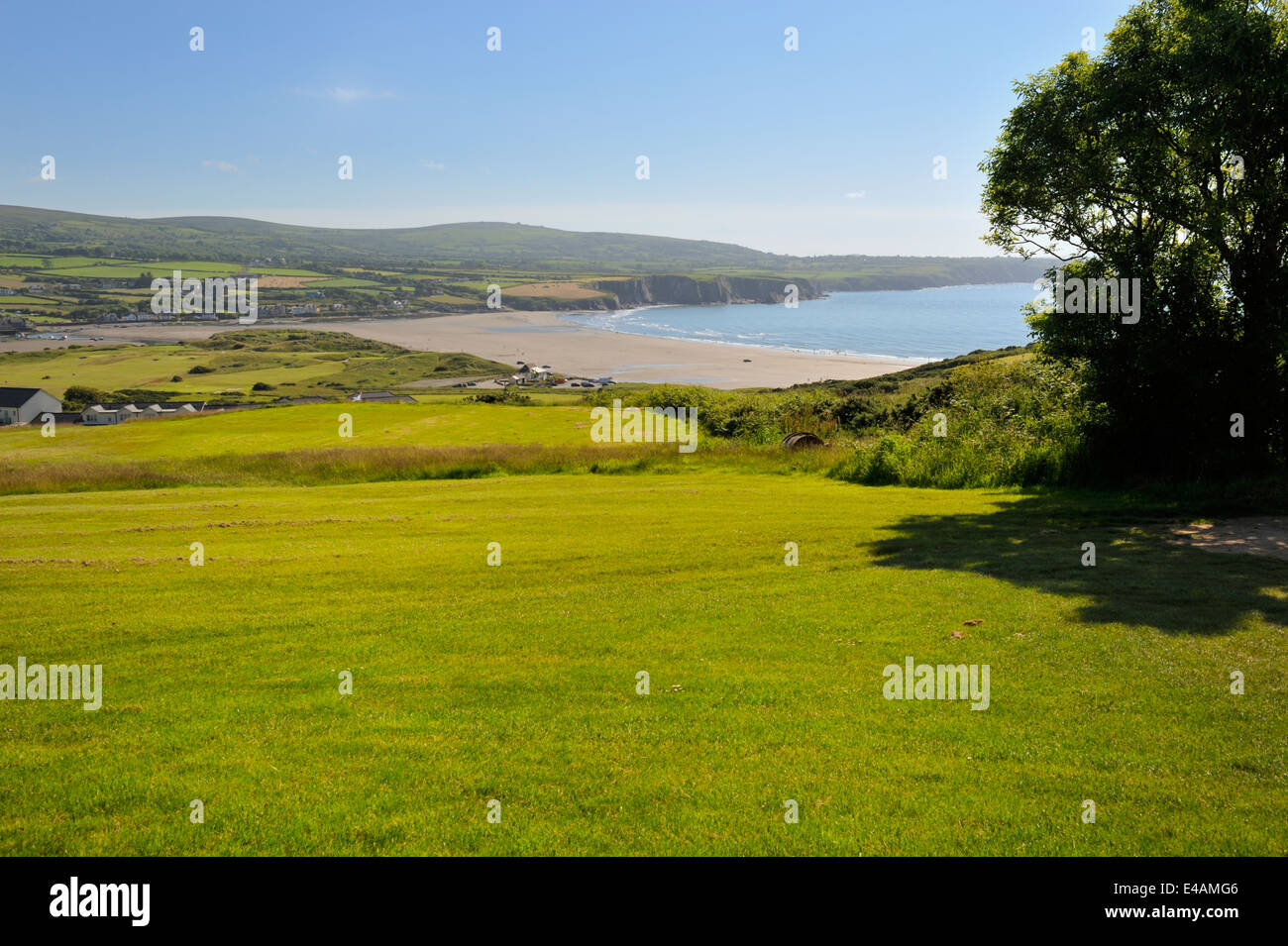 Green fields of Newport Links Golf Club looking down to distant Newport Sands Beach, Wales, UK Stock Photo