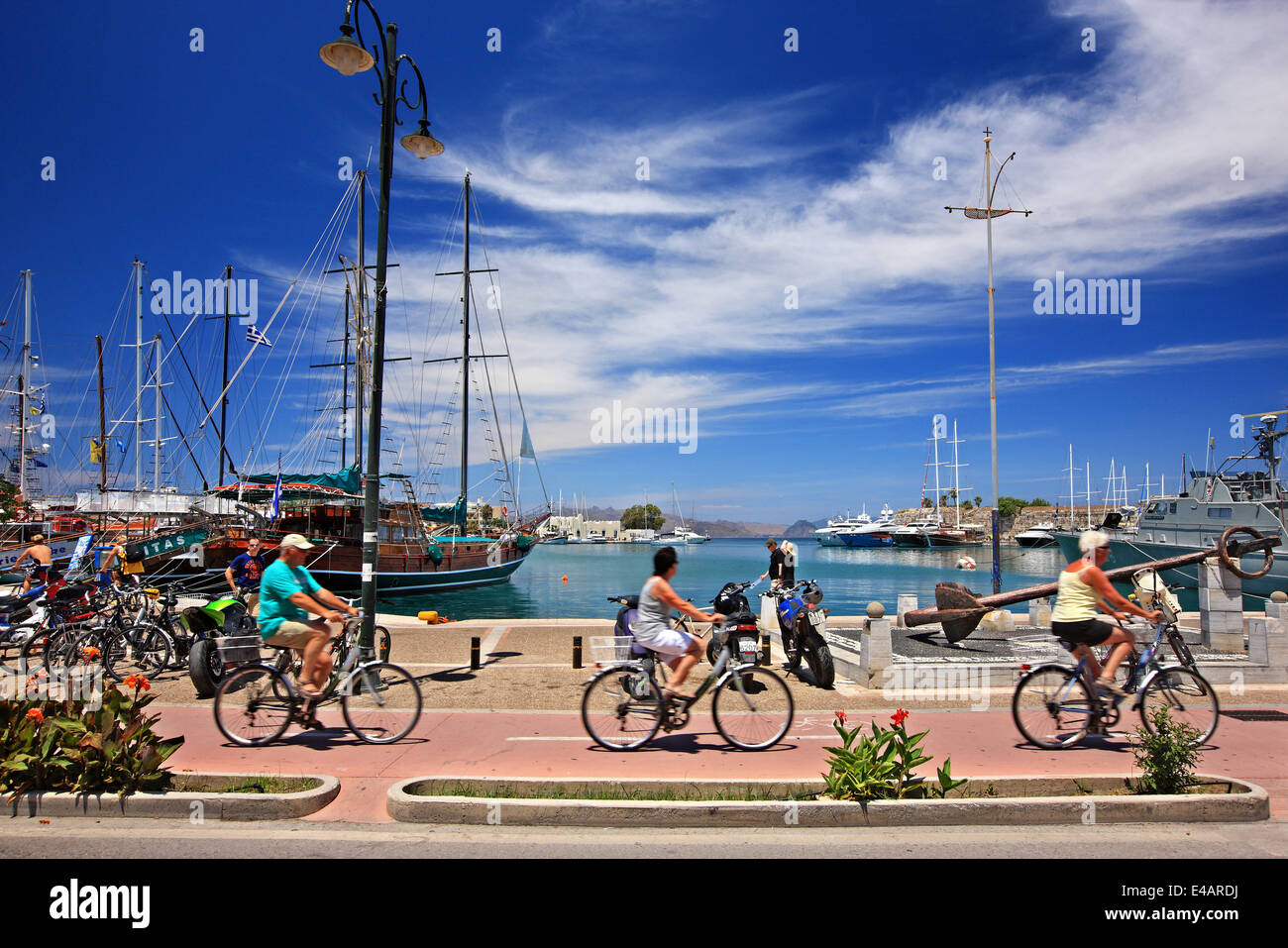 Cyclists at the old harbor of Kos town, Kos island Dodecanese, Greece. Stock Photo