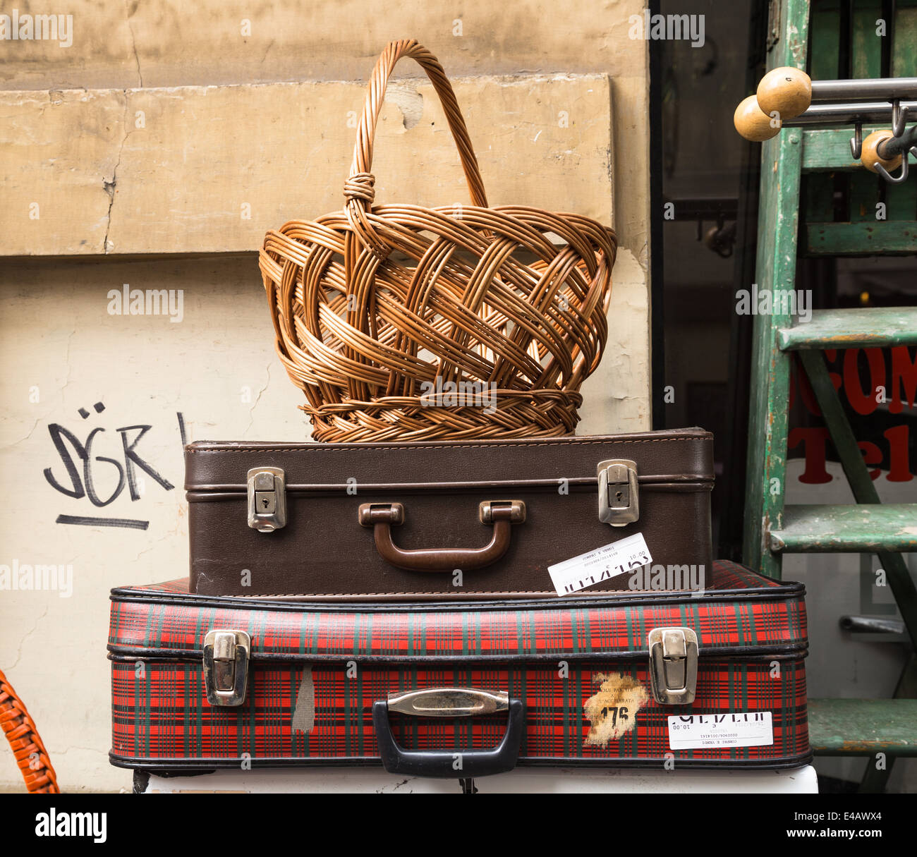 Wicker basket and suitcases in a junk shop display, Turin, Piedmont, Italy. Stock Photo
