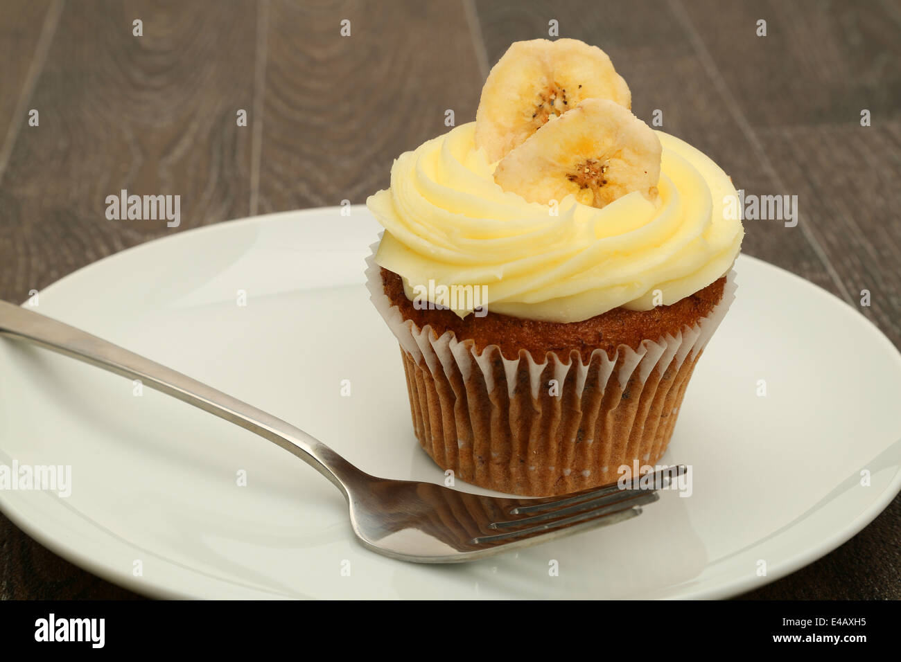 A banana cupcake topped with buttercream icing, studio shot Stock Photo