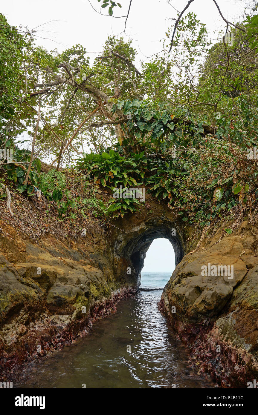 Natural tunnel in the rock dug by the sea on the Caribbean shore of Costa Rica, Punta Uva, Puerto Viejo Stock Photo