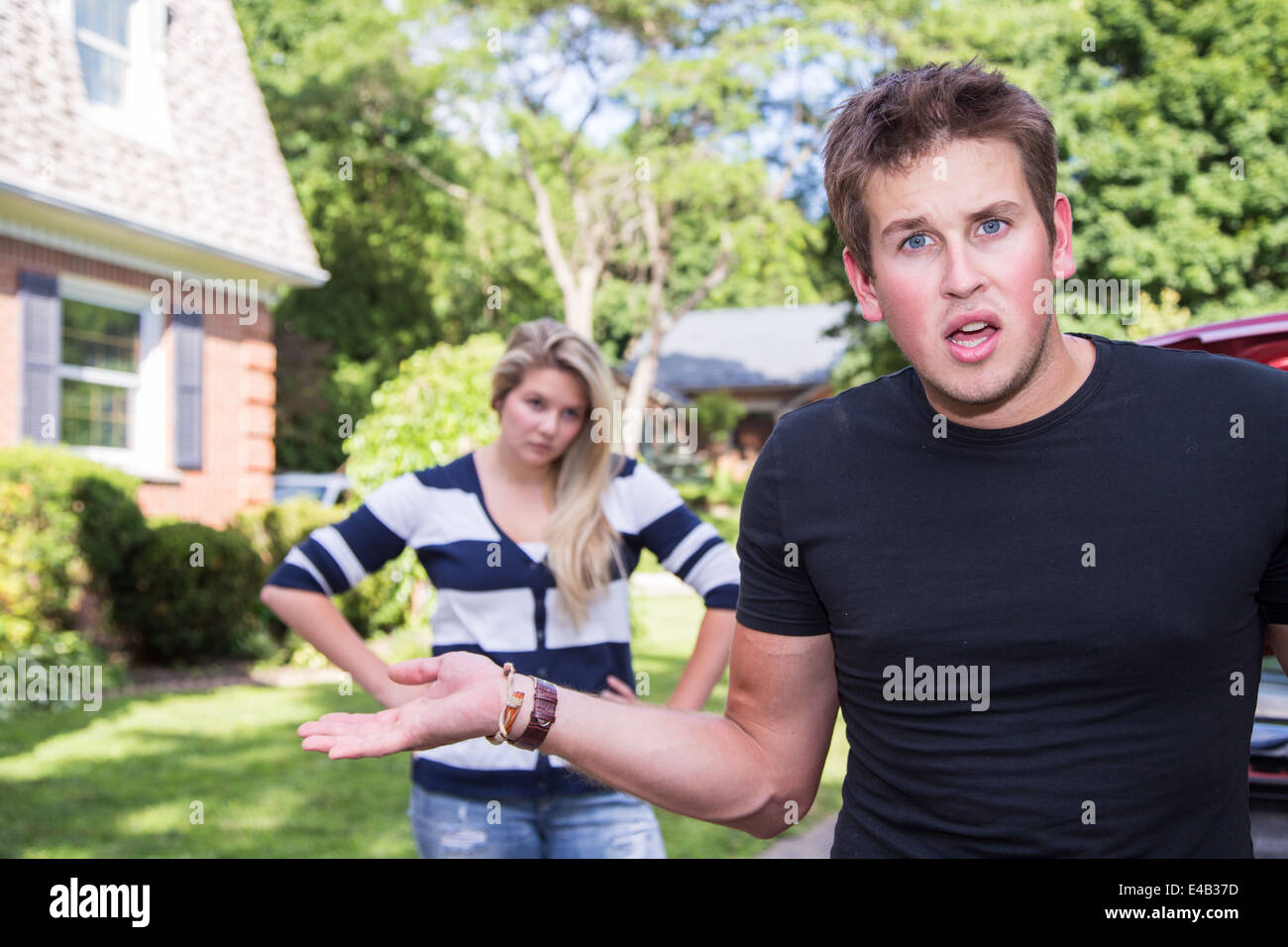 A young man shows frustration in an argument with his girlfriend Stock Photo