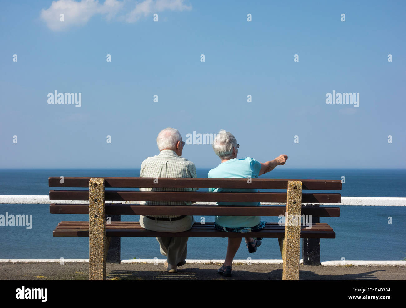 Elderly couple sitting on bench overlooking sea. UK Stock Photo - Alamy