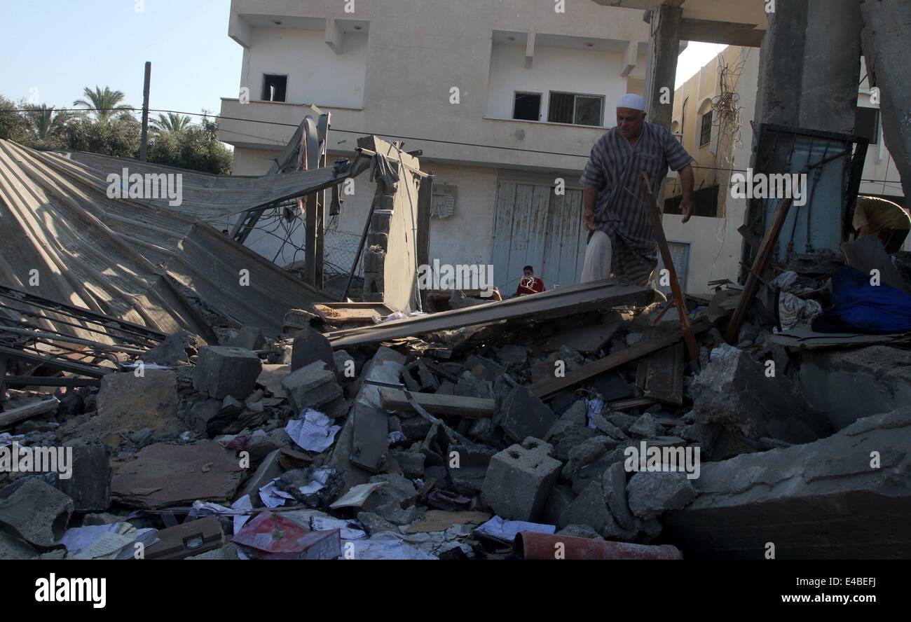 April 16, 2010 - Khan Younis, Gaza Strip, Palestinian Territory - A Palestinian man inspects a house which police said was destroyed in an Israeli air strike in Khan Younis in the southern Gaza Strip July 8, 2014. Israel launched an offensive against Islamist Hamas in the Gaza Strip on Tuesday, bombing some 50 targets, including homes, in a campaign meant to end Palestinian rocket fire into the Jewish state. The Israeli military said it targeted about 50 sites in aerial and naval assaults. Palestinian officials said more than 30 of them were bombed in little more than an hour before dawn, incl Stock Photo