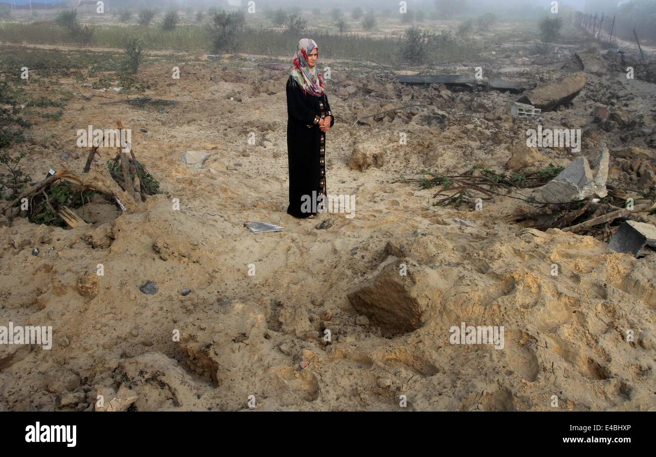 April 16, 2010 - Khan Younis, Gaza Strip, Palestinian Territory - A Palestinian woman looks on the rubble her house which police said was destroyed in an Israeli air strike in Khan Younis in the southern Gaza Strip July 8, 2014. Israel launched an offensive against Islamist Hamas in the Gaza Strip on Tuesday, bombing some 50 targets, including homes, in a campaign meant to end Palestinian rocket fire into the Jewish state. The Israeli military said it targeted about 50 sites in aerial and naval assaults. Palestinian officials said more than 30 of them were bombed in little more than an hour be Stock Photo