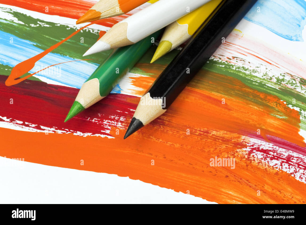 multi colored pencils on funny painted paper Stock Photo