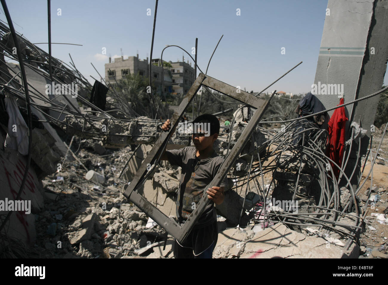 Khan Younis, Gaza Strip, Palestinian Territory. 8th July, 2014. A Palestinian boy inspects a house which police said was destroyed in an Israeli air strike in Khan Younis in the southern Gaza Strip July 8, 2014. Israel launched an offensive against Islamist Hamas in the Gaza Strip on Tuesday, bombing some 50 targets, including homes, in a campaign meant to end Palestinian rocket fire into the Jewish state. The Israeli military said it targeted about 50 sites in aerial and naval assaults. Credit:  ZUMA Press, Inc./Alamy Live News Stock Photo