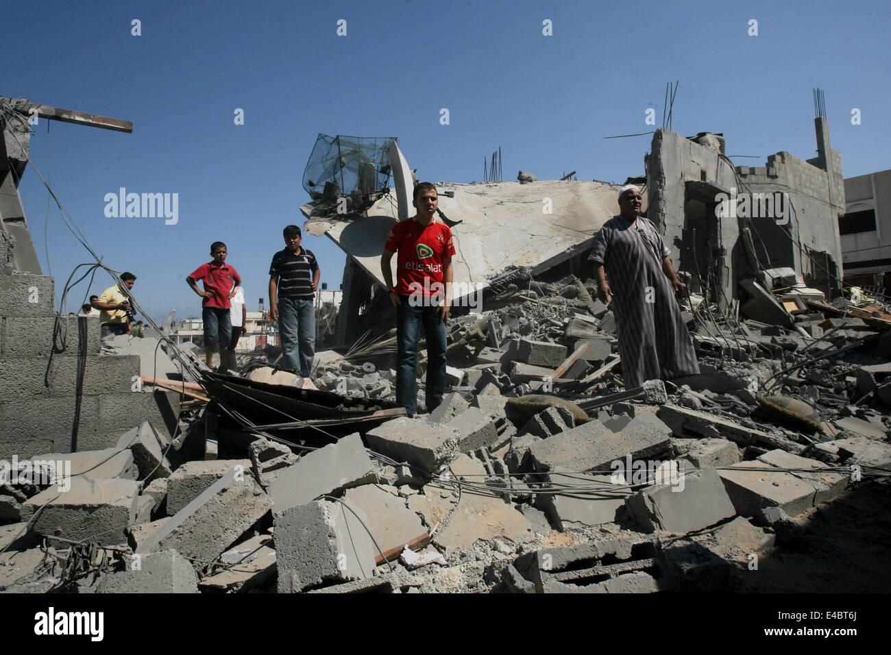 Khan Younis, Gaza Strip, Palestinian Territory. 8th July, 2014. Palestinians inspect a house which police said was destroyed in an Israeli air strike in Khan Younis in the southern Gaza Strip July 8, 2014. Israel launched an offensive against Islamist Hamas in the Gaza Strip on Tuesday, bombing some 50 targets, including homes, in a campaign meant to end Palestinian rocket fire into the Jewish state. The Israeli military said it targeted about 50 sites in aerial and naval assaults. Credit:  ZUMA Press, Inc./Alamy Live News Stock Photo