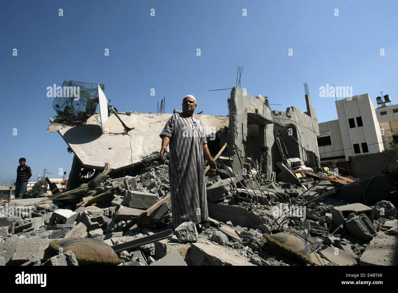 Khan Younis, Gaza Strip, Palestinian Territory. 8th July, 2014. A Palestinian man inspects a house which police said was destroyed in an Israeli air strike in Khan Younis in the southern Gaza Strip July 8, 2014. Israel launched an offensive against Islamist Hamas in the Gaza Strip on Tuesday, bombing some 50 targets, including homes, in a campaign meant to end Palestinian rocket fire into the Jewish state. The Israeli military said it targeted about 50 sites in aerial and naval assaults. Credit:  ZUMA Press, Inc./Alamy Live News Stock Photo