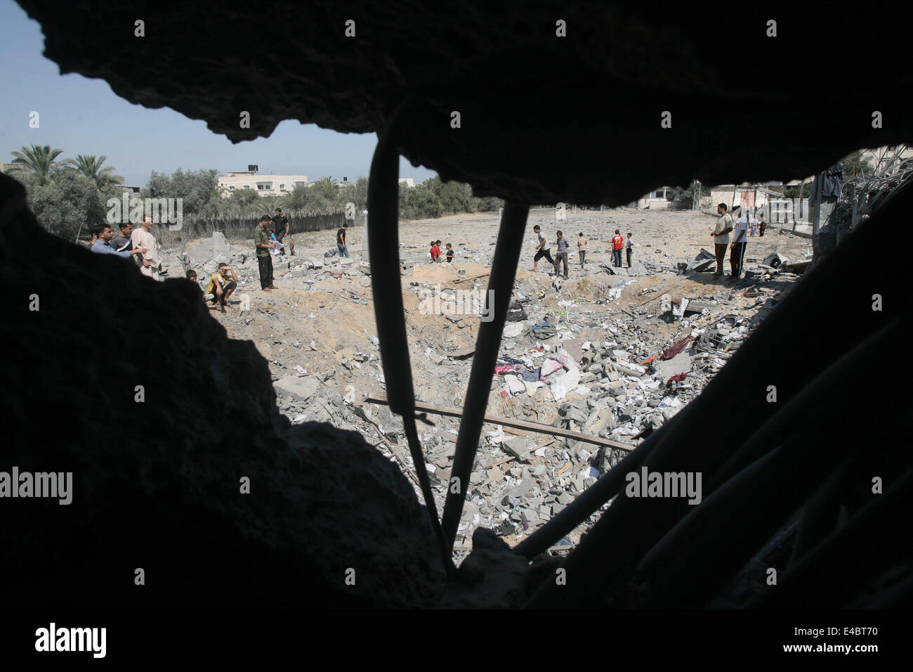 Khan Younis, Gaza Strip, Palestinian Territory. 8th July, 2014. Palestinians inspect a house which police said was destroyed in an Israeli air strike in Khan Younis in the southern Gaza Strip July 8, 2014. Israel launched an offensive against Islamist Hamas in the Gaza Strip on Tuesday, bombing some 50 targets, including homes, in a campaign meant to end Palestinian rocket fire into the Jewish state. The Israeli military said it targeted about 50 sites in aerial and naval assaults. Credit:  ZUMA Press, Inc./Alamy Live News Stock Photo