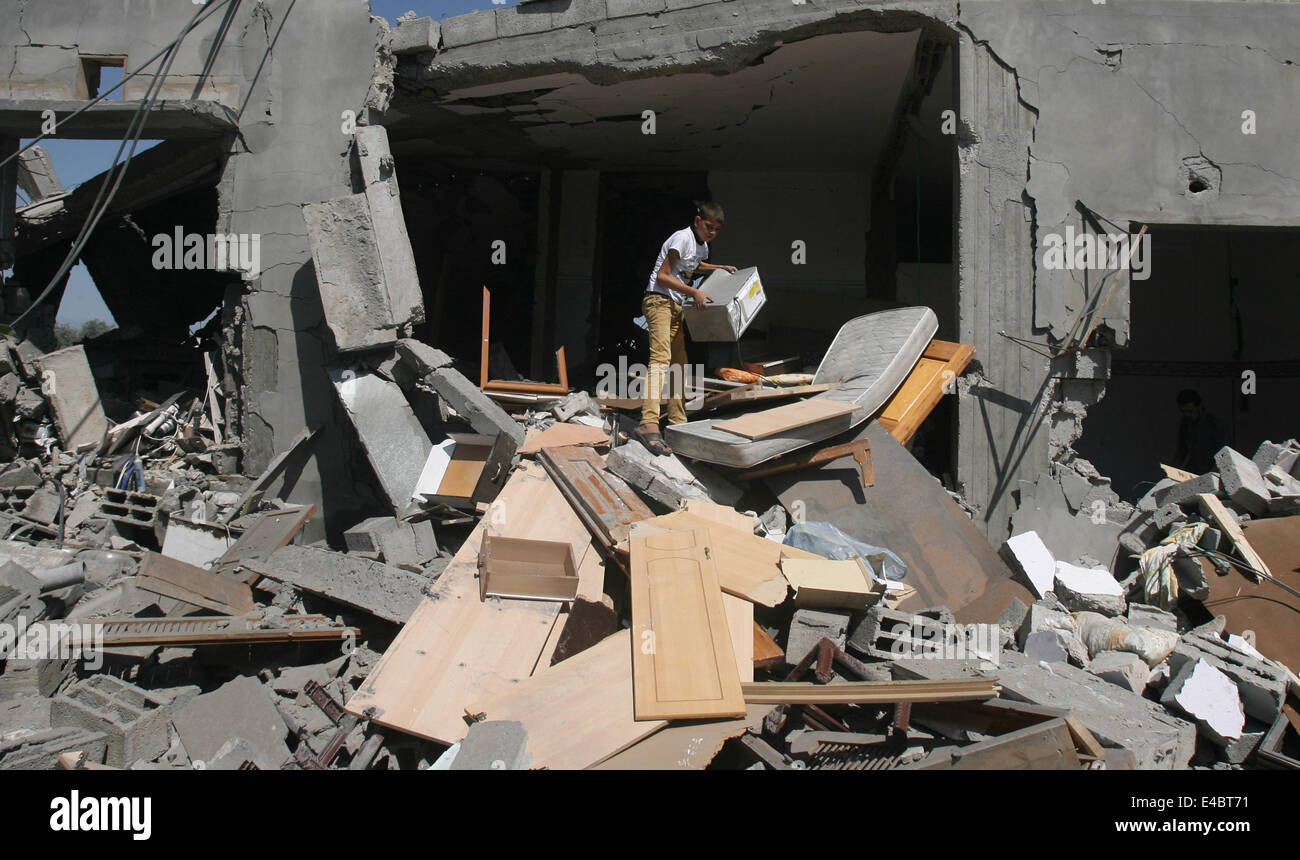 Khan Younis, Gaza Strip, Palestinian Territory. 8th July, 2014. A Palestinian boy inspects a house which police said was destroyed in an Israeli air strike in Khan Younis in the southern Gaza Strip July 8, 2014. Israel launched an offensive against Islamist Hamas in the Gaza Strip on Tuesday, bombing some 50 targets, including homes, in a campaign meant to end Palestinian rocket fire into the Jewish state. The Israeli military said it targeted about 50 sites in aerial and naval assaults. Credit:  ZUMA Press, Inc./Alamy Live News Stock Photo