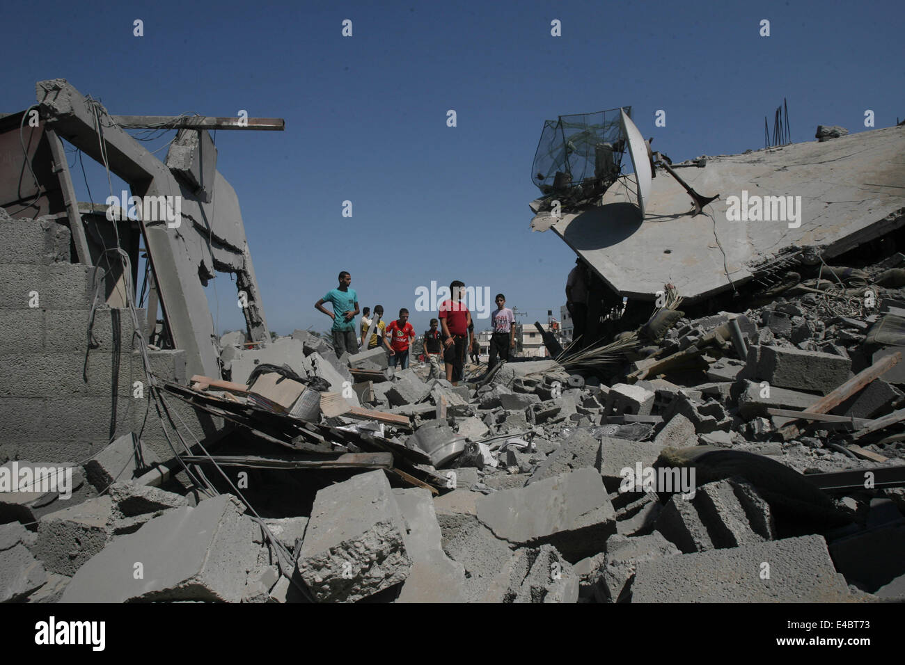 Khan Younis, Gaza Strip, Palestinian Territory. 8th July, 2014. Palestinians inspect a house which police said was destroyed in an Israeli air strike in Khan Younis in the southern Gaza Strip July 8, 2014. Israel launched an offensive against Islamist Hamas in the Gaza Strip on Tuesday, bombing some 50 targets, including homes, in a campaign meant to end Palestinian rocket fire into the Jewish state. The Israeli military said it targeted about 50 sites in aerial and naval assaults. Credit:  ZUMA Press, Inc./Alamy Live News Stock Photo